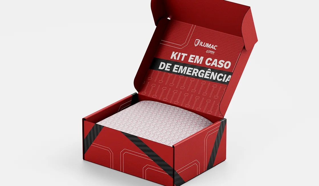 Caixa de papelão vermelha aberta, com o logotipo ILUMAC e a chamada “Kit em caso de emergência” impressos na tampa