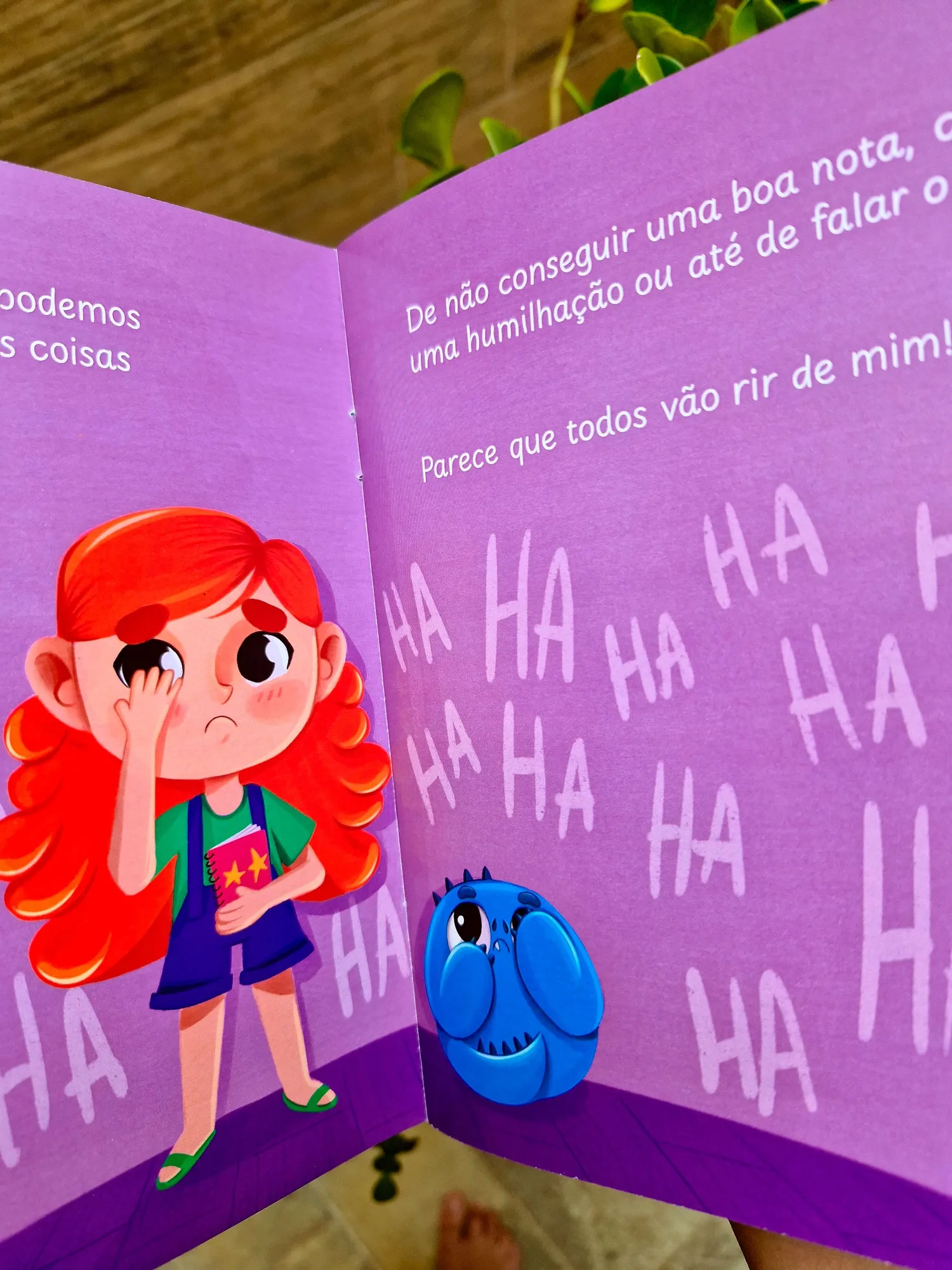 Página dupla roxa do livro impresso com a personagem Luna emocionada e o Monstrinho ao fundo